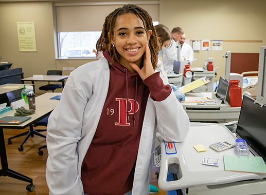 Nursing student in the lab smiling at the camera